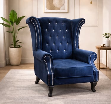 Elegant royal blue velvet wingback armchair with silver stud trim and button tufting in a modern living room.