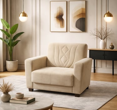 Modern beige upholstered armchair in a minimalist living room with neutral decor and gold pendant lights.