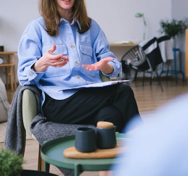 A person sitting in a chair with a notebook offering guidance