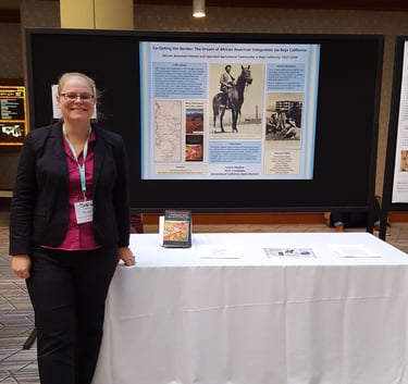 Laura Hooton, left, standing with Little Liberia poster, AHA 2017