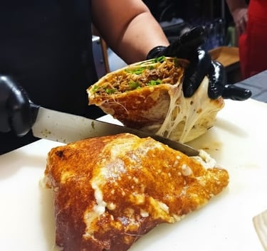 a person cutting a sandwich with a knife and knife