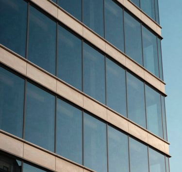 A close-up of a glass building facade reflecting a clear North American sky, emphasizing sharp geometric lines and a deep blue and off-white color palette, capturing a sense of modern infrastructure and reliability.