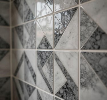 Close-up photography of intricate geometric wall tile installation in a luxury bathroom, showcasing precise craftsmanship and sophisticated charcoal and white colors.
