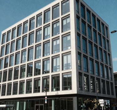 The exterior of a modern, professional business centre in Cardiff, Wales, with clean architectural lines, glass frontage, and a clear blue sky, capturing a sense of stability and growth.