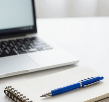 A clean, minimalist workspace with a laptop, a notebook, and a professional blue pen on a desk. Soft natural lighting. Colors: #F5F8FA, #A0C2D9, #1E3A4D.