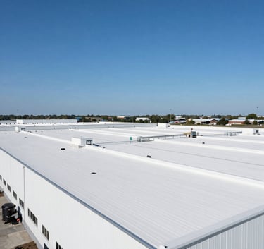 Wide-angle photograph of a large, clean white commercial flat roof on a massive distribution center in New Jersey, clear blue sky, professional industrial photography style.