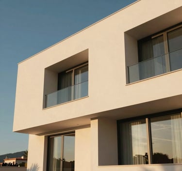 Low-angle architectural photography of a modern luxury villa in Castellón, featuring off-white facades and large windows, captured during the golden hour in a Southern European / Spanish landscape.