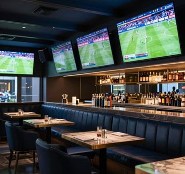 A wide shot of a modern, luxurious sports bar with multiple large screens displaying various international football matches, sophisticated furniture, elegant lighting in dark navy and steel blue, Southeast Asian / Vietnamese context.