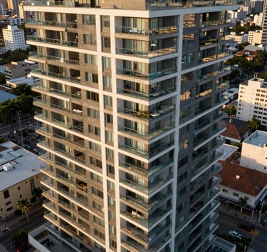 An aerial wide shot of a contemporary luxury condominium building in a South American urban setting, clean lines, glass balconies, during golden hour.