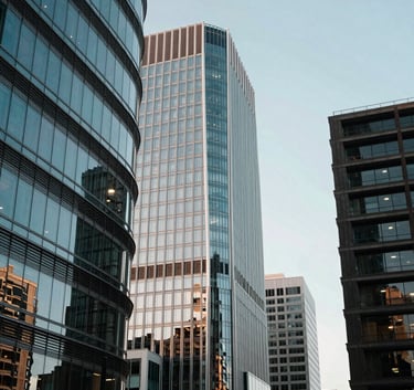 A visionary architectural view of a contemporary North American / US innovation hub, with sleek lines and glass facades reflecting a soft blue sky. The atmosphere is impactful and trustworthy, emphasizing a forward-thinking mission.