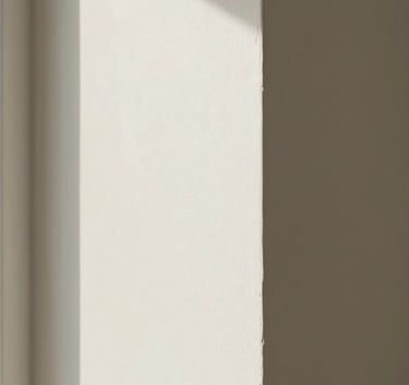 A high-quality photograph showing a finished, smooth off-white drywall corner in a luxury North American / US residential living room. The focus is on the perfectly straight edges and seamless texture under natural morning light.