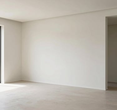A wide-angle interior shot of a contemporary living room with perfectly finished plaster walls and a suspended ceiling with clean lines. The room is empty and bathed in natural light, showcasing the quality of the paint and finishes. Modern and high-end atmosphere.