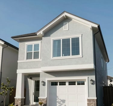 A professional, low-angle shot of a modern, clean-lined residential property in a North American / US suburb, with clear blue skies and soft mint grey exterior accents under bright, natural daylight.