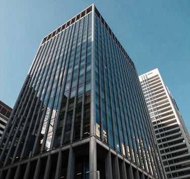 Modern corporate architecture in Sydney, Australia, with clean lines and glass facades reflecting a clear blue sky. The shot is an upward angle, symbolizing growth, professionalism, and high-level expertise.