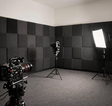 A professional wide shot of a modern media production studio in Los Angeles, featuring dark grey acoustic panels and high-end cinematic equipment under soft off-white lighting.