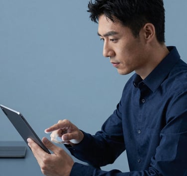 A focused developer in a modern North American / US office environment interacting with a high-resolution Android tablet. The aesthetic is minimalist with alice blue and dark navy tones reflecting technical precision.