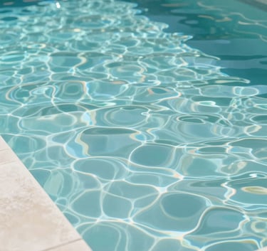 A wide, high-angle shot of a luxurious backyard pool with sparkling, transparent water. The pool has modern #F5FAFB stone coping. The scene is bright and airy with subtle reflections of the brand's teal colors in the ripples. No people are visible, emphasizing calm and clarity.