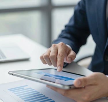 A focused business professional analyzing strategy documents on a sleek tablet in a bright office, featuring #94B0C7 highlights.