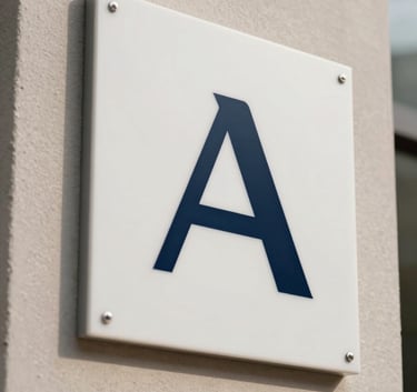 A crisp, modern close-up of a minimalist company logo plate on a textured wall in a Global / International agency entrance, with elegant dark navy and soft off-white accents.