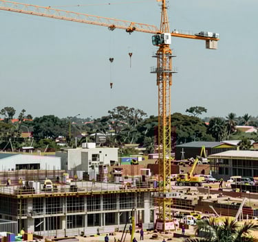A wide-angle shot of a large-scale construction site in Colombia with cranes and foundation work in progress. The lighting is bright and clear, emphasizing operational capacity. Tones of #0B1C2E and #345D7E are present in the machinery and safety gear.