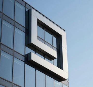 A sophisticated logo-style photograph of an architectural detail, featuring sharp geometric lines of a modern North American glass building against a clear blue sky. The composition is clean and minimalist, using shadows and light to emphasize structural integrity and professional design.