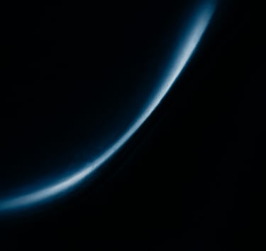 A dark, moody abstract photograph of light reflecting off a polished obsidian surface, creating soft blue gradients. Elegant, minimalist composition with an aura of exclusive anticipation.
