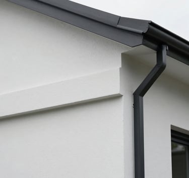A high-quality close-up of a freshly painted white residential exterior wall meeting a charcoal black trim, showcasing perfect clean lines and premium texture, Auckland architectural style.