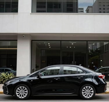 A full side profile of a polished deepest obsidian black Corolla parked in front of a modern minimalist corporate building in a South American / Brazilian business district. Natural daylight, sharp reflections on the car's surface. Professional photography.