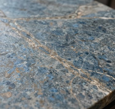 Macro photography of a high-end slate blue and taupe stone surface with subtle metallic veins, professional lighting, Northern European / Dutch luxury interior detail.