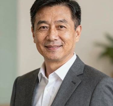 A professional portrait of a mature and experienced candidate with a warm, confident expression. The subject wears a dark grey (#262626) suit and is positioned in a professional setting with soft, warm lighting. The background features subtle textures of #F2F4F3 and a hint of #A3B18A green to evoke a sense of calm authority and deep-rooted credibility.