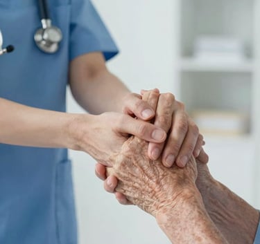 A detailed close-up of a nurse's hand gently and supportively holding the hand of an elderly patient. The background shows a clean, modern North American home interior with soft blue and white accents.
