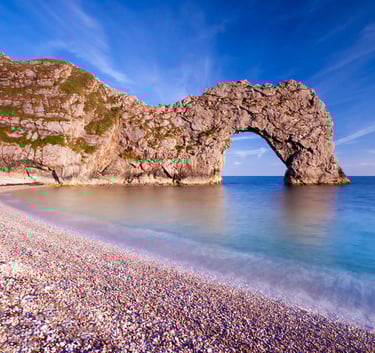 a large rock formation in the middle of a beach