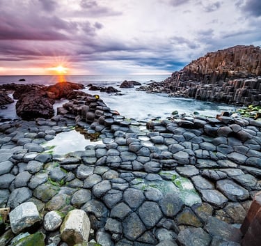 a sunset over a rocky beach with a sunset