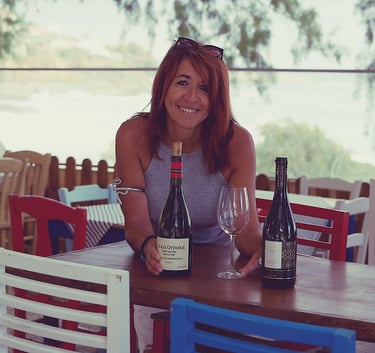 a sommeliere sitting at a table with wine glasses and greek bottles of wine in chania