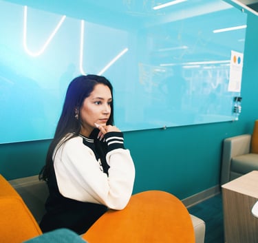 a guide gal and woman sitting in a chair in a room