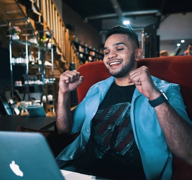 a guide man sitting in a chair with a laptop