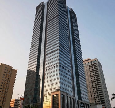 A wide-angle exterior shot of a modern architectural building in a prominent business district of Bangalore, South Asian / Indian urban environment, sunset lighting casting soft shadows on glass and steel.