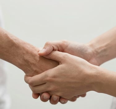 A close-up shot of hands coming together in a supportive gesture, clean modern aesthetic, soft natural lighting, emphasizing themes of compassion and trust, with a color palette reflecting #FDFBF8 and #C1B4A5.