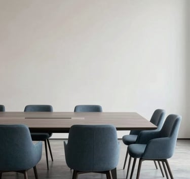 A wide-angle, minimalist photography of a modern boardroom with a sleek table and slate blue chairs. The background is a crisp soft off-white gallery wall. Professional and serene atmosphere.