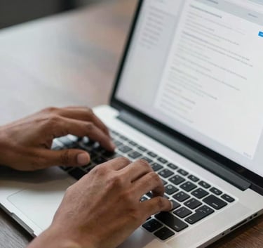 Close-up photography of a software developer's hands, a South Asian professional, typing on a modern laptop in a sleek office, focus on the screen showing a clean user interface.