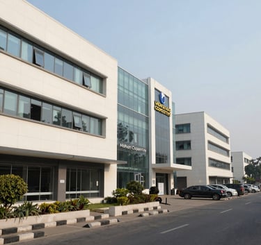 A professional wide-angle shot of a commercial complex at Mohan Cooperative, Delhi. The scene features modern architecture with clean lines in Soft Off-White and glass. The atmosphere is bustling yet orderly, typical of a premier South Asian / Indian industrial and corporate hub.