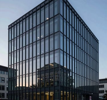 A wide shot of a modern, minimalist glass office building at dusk, reflecting deep navy blue and charcoal gray hues. The lighting is crisp and clear, conveying authority and trust in a professional B2B setting.