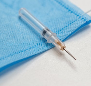 A sharp, clear macro photograph of a sterile medical cannula tip, minimalist composition, bright light blue and off-white tones, Global / International healthcare context.