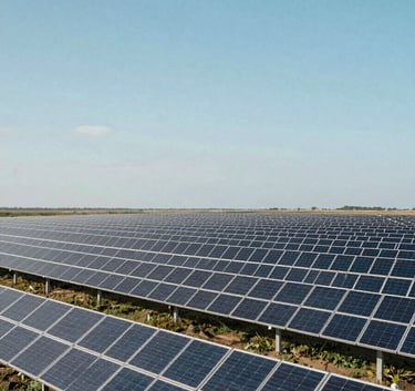 A clean, bright photograph of a massive solar farm array stretching to the horizon under a soft cerulean sky, capturing the scale of renewable energy infrastructure.