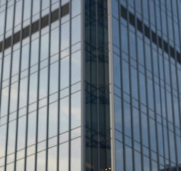 A sophisticated close-up of a modern corporate skyscraper's glass facade reflecting a clear sky, dominated by tones of #2C3E50 and #5D6D7E, conveying strength and stability.