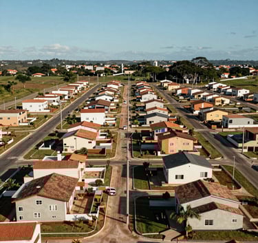 High-angle shot of a newly developed residential land subdivision in Brazil showing organized power lines and infrastructure under a clear blue sky, South American architecture style.