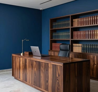 A wide-angle professional photograph of a contemporary Brazilian law firm interior. The decor is minimalist with deep blue accents, high-quality dark wood furniture, and a shelf of leather-bound books, conveying gravitas and reliability.