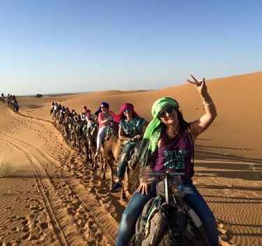 Dunas do Deserto do Saara ao pôr do sol, passeio de camelo em Marrocos, turismo de luxo.