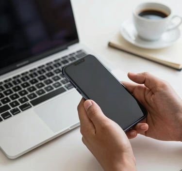 Close-up photography of a professional South American person's hands using a smartphone and a sleek laptop on a white desk, with a cup of coffee and notebook, clean and professional style.