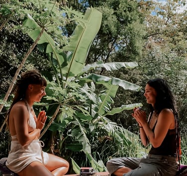 two women sitting on a deck with a cup of tea and tarot oracle cards